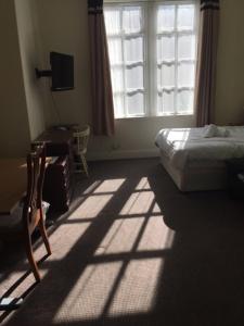 克莱克西顿Gateway Lodge的一间卧室配有一张床、一个窗口和一张书桌