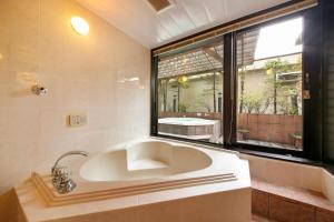 札幌阿奈克斯酒店的带窗户的浴室设有大浴缸
