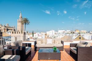 塞维利亚Puerta Principe Luxury Apartments的带家具的阳台,享有城市美景