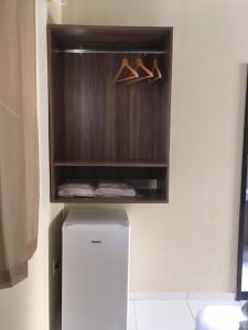 卡鲁阿鲁Pousada Sumaré的客房设有冰箱和木制橱柜。