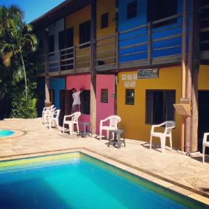 马利西亚斯Maresias Hostel & Suites的一座带游泳池和椅子的酒店和一座建筑