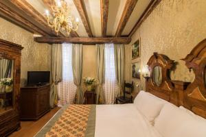 威尼斯尼科洛浦瑞里酒店的一间卧室配有一张大床和一个吊灯。