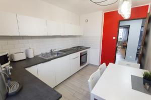托伦Nest Arena Toruń的厨房配有白色橱柜和红色墙壁
