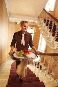 瓦萨阿斯特酒店的一位女士从楼梯上走下来,带着一盘水果