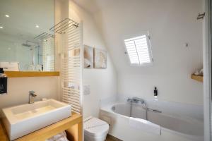 德哈恩及时行乐浪漫庄园酒店的带浴缸、卫生间和盥洗盆的浴室