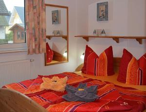 勒伯尔Müritzblick 36的一间卧室配有红色枕头的床