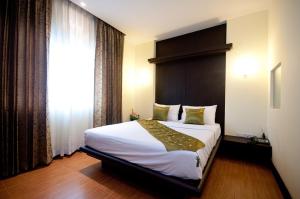 曼谷暹罗天堂娱乐综合酒店的一间卧室设有一张大床和一个窗户。