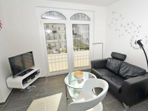 奥斯赛拜-塞林Villa Lena - Wohnung 11的客厅配有黑色真皮沙发和电视