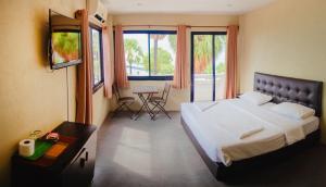 乔木提恩海滩GI旅馆的一间卧室配有一张大床和一张桌子及椅子