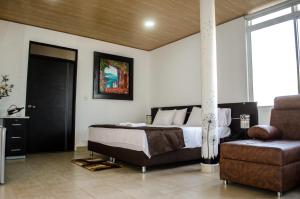 阿劳卡Hotel Quinta del Sol的一间卧室配有一张床、一张沙发和一把椅子