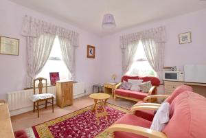 海斯Sunny Bank Guest House的客厅配有粉红色的沙发和桌子