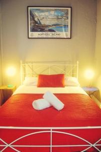 贝尔法斯特Vagabonds Hostel的一张红色和白色的床,上面有两条毛巾
