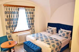 梅尔克巴本贝格旅馆的一间卧室配有一张床、一张桌子和一个窗户。
