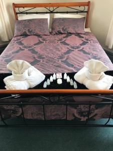 Waiuku肯特酒店的一张木架床,上面有两条毛巾