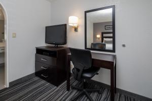 红木城红木溪汽车旅馆的客房设有一张带电视和镜子的书桌
