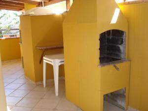 邦比尼亚斯Residencial Sol Nascente的黄色的厨房配有桌子和壁炉