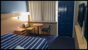 温莎温莎汽车旅馆的酒店客房带一张床、一张桌子和椅子