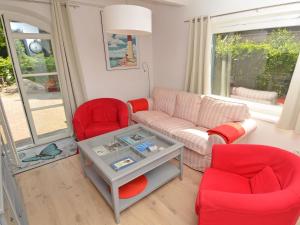 奥斯赛拜-塞林Blaues Strandhaus Sellin的客厅配有红色椅子和沙发
