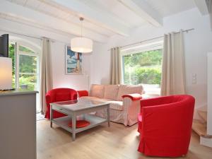 奥斯赛拜-塞林Blaues Strandhaus Sellin的客厅配有红色椅子和桌子