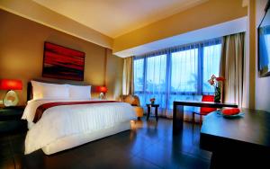 库塔100 Sunset Kuta Hotel & Ballroom的一间卧室设有一张大床和一个大窗户