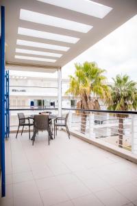 拉戈斯B06 - Top-Floor Marina 2 bed Apartment的阳台配有桌椅和棕榈树。