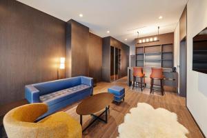 江陵市Skybay Hotel Gyeongpo的客厅配有蓝色的沙发和椅子