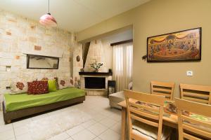 赫索尼索斯套房之家旅馆的客厅设有绿色沙发和壁炉