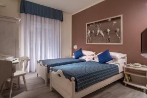 阿尔比尼娅Hotel Corallo的一间卧室配有蓝色和白色床单