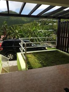 圣马丁岛Over The Hill Residence的停泊在车道上,在阳台上停车的汽车