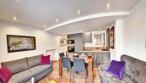 安锡L'atout charme的客厅配有沙发和带紫色枕头的桌子