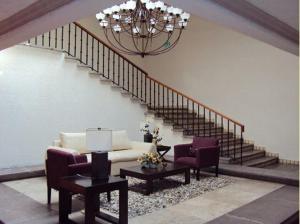 杜兰戈统治者酒店的客厅配有沙发和两把椅子,设有楼梯