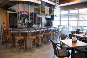 昂基奥贝格兰巴瑟迪乐酒店的餐厅设有酒吧,配有木桌和椅子