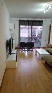 马塔罗Apartamento Mataro的客厅配有桌子、沙发和电视