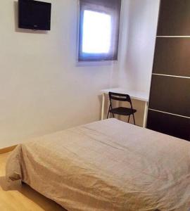 马塔罗Apartamento Mataro的卧室配有床、椅子和窗户。