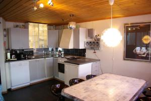 努尔黑姆松Hardanger Feriesenter Nesvika的厨房配有白色橱柜和桌椅