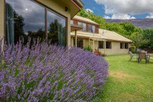 瓦纳卡阿尔塔蒙特旅舍的一座花园,在房子前面种有紫色的花朵