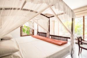 拉维尼亚山马特山林小屋精品酒店的一间卧室配有一张天蓬床和窗户