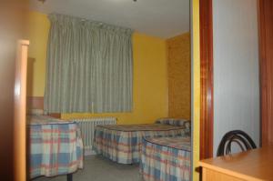 Numancia de la Sagra梅斯旅馆的客房设有两张床和窗户。