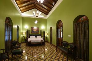 帕纳吉Surya Kiran Heritage Hotel的一间设有床铺的卧室,位于一个拥有绿色墙壁的房间