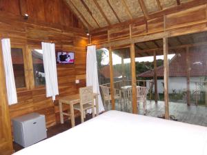 乌鲁瓦图绿碗海滩别墅的客房设有木墙和带桌椅的窗户。