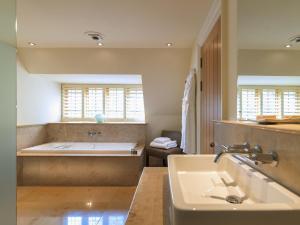 查格福德Gidleigh Park- A Relais & Chateaux Hotel的带浴缸和盥洗盆的浴室