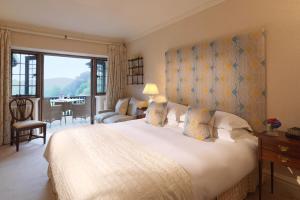 查格福德Gidleigh Park- A Relais & Chateaux Hotel的一间卧室设有一张大床和一个大窗户