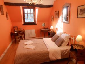 Pontlevoy博尔德农场住宿加早餐旅馆的一间卧室拥有橙色的墙壁和一张大床