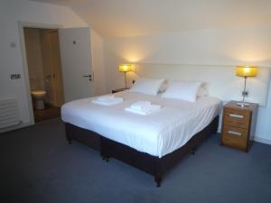 卡斯尔马特Castlemartyr Holiday Mews 3 bed的卧室配有一张白色大床和两条毛巾