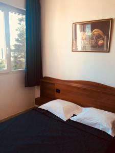巴斯蒂亚桑浦日罗酒店的一间卧室配有一张床,窗户配有图片