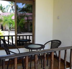 达累斯萨拉姆Serene Beach Resort的阳台配有桌椅和镜子