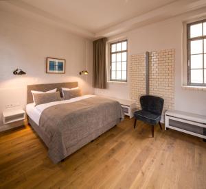 柏林奥德贝格酒店的一间卧室配有一张大床和一把椅子