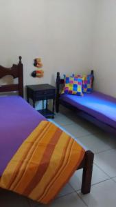 卡波布里奥Casa na Praia do Forte的一间设有两张床和一张桌子的房间