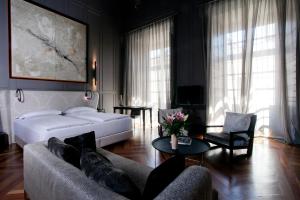 塞维利亚CoolRooms Palacio Villapanés的一间卧室配有一张床、一张沙发和一张桌子