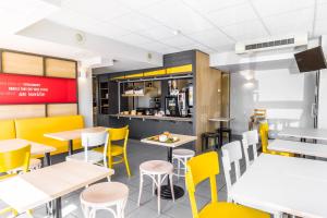 巴伯雷圣叙尔皮斯B&B HOTEL Troyes Barberey的用餐室配有桌子和黄色椅子